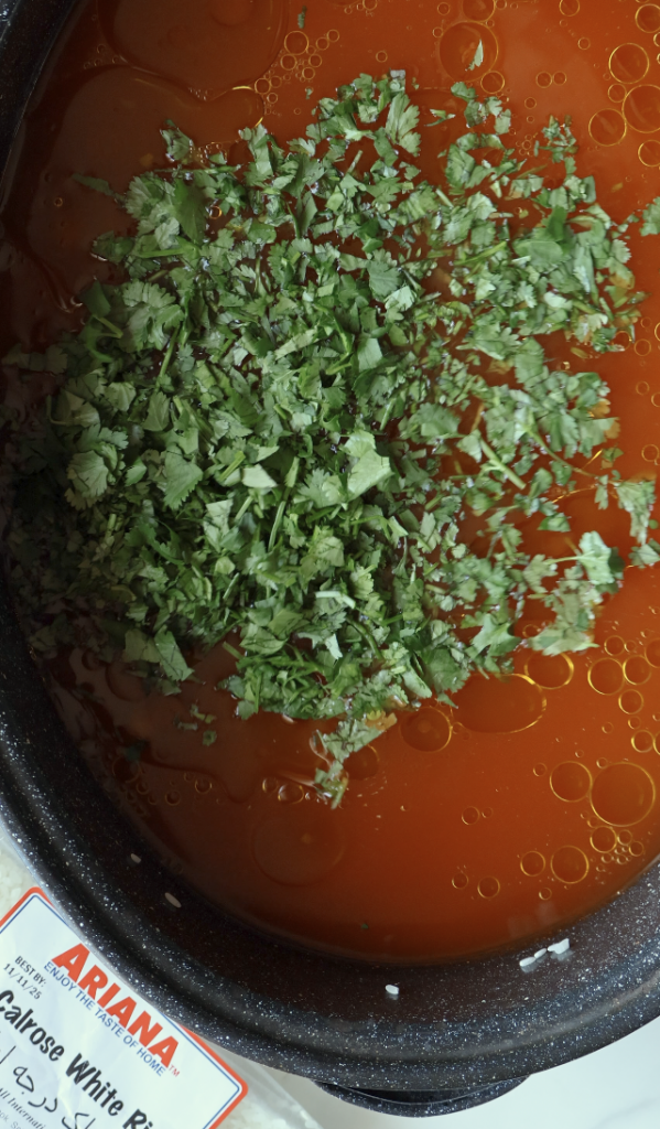 chopped cilantro being thrown into the Calrose rice and mung beans